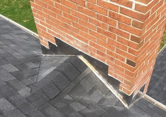 chimney lead flashing installed on a new red brick chimney